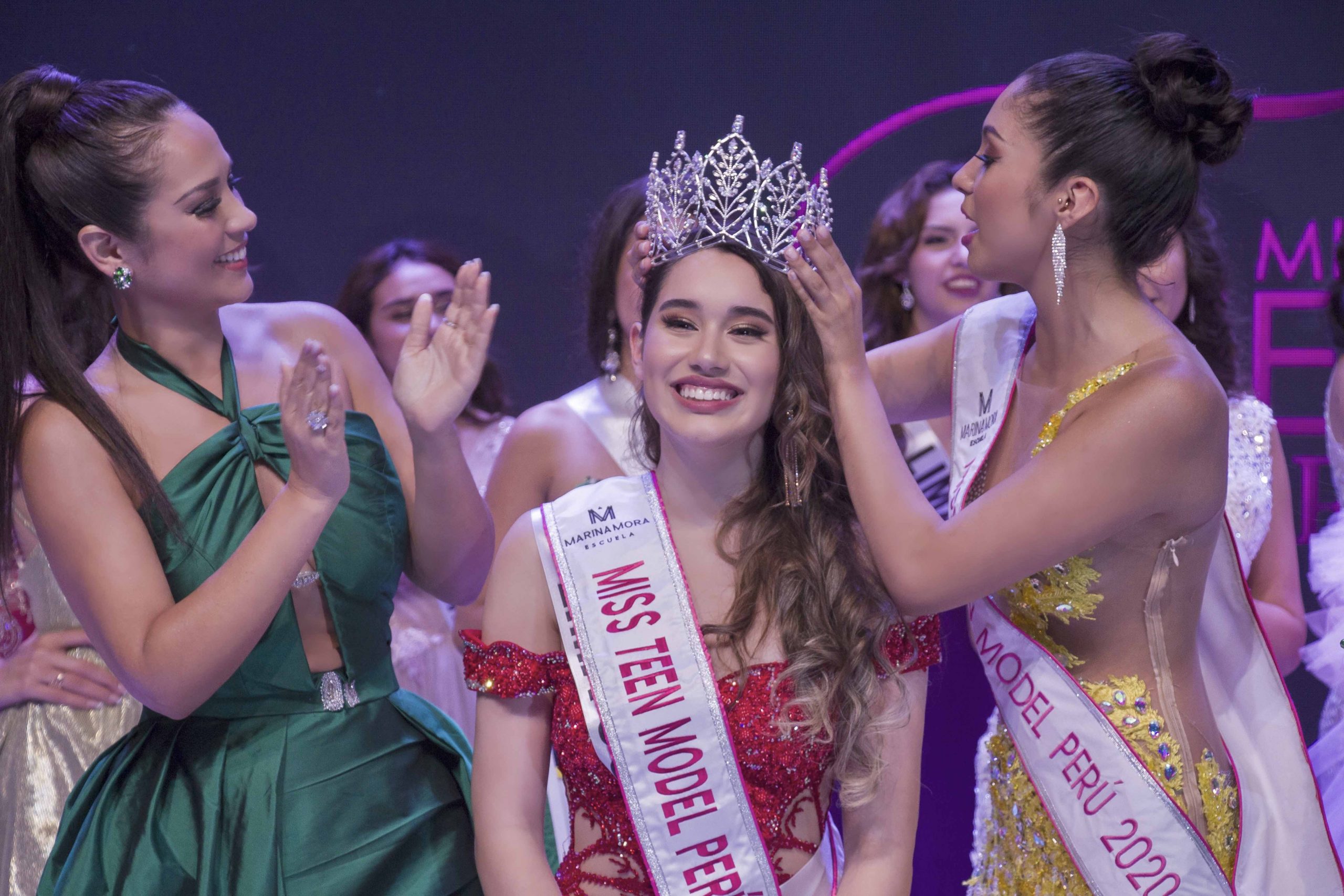 Primer plano de la ganadora sonriendo en el instante en que le colocan la corona